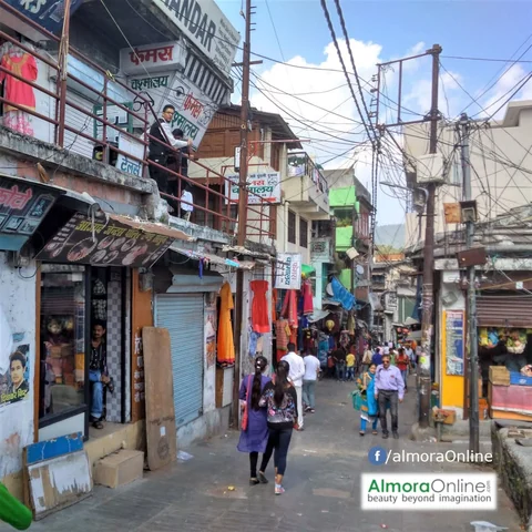 Shops and pedestrians along a narrow market street in Almora